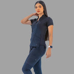 Full body view of a woman wearing a navy blue Style 930 scrub top and matching pants, posing against a grey background.