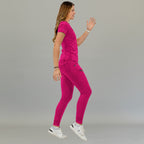 Jogger quirúrgico mujer 905 fucsia, vista lateral de una modelo caminando con bolsillos laterales y puños en los tobillos